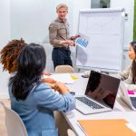 Managers presenting growth strategies to coworkers in coworking office